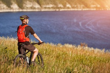 Çekici bisikletçi rirding dağ bisikleti kırsal alanında güzel Nehri üzerinde.