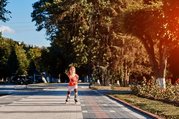 Chica bonita en el aprendizaje de camiseta roja para patín al aire libre en día hermoso de verano — Foto de Stock