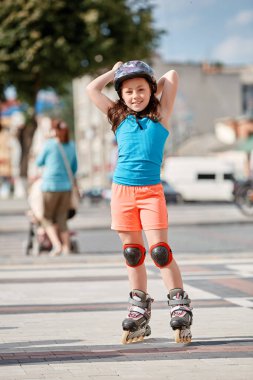 Sevimli küçük kız paten için açık havada güzel yaz günü öğrenme