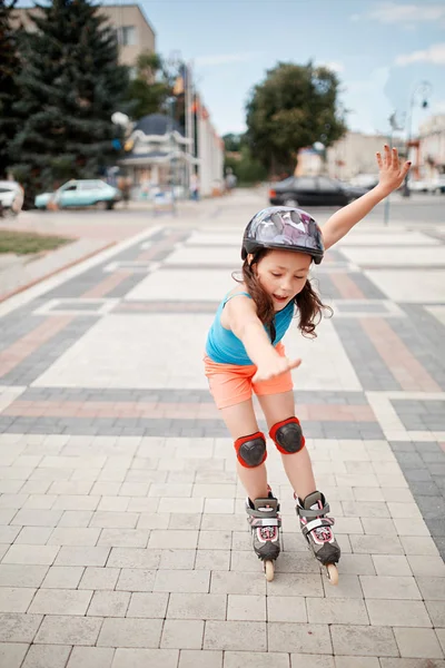 Linda niña aprendiendo a patinar al aire libre en un hermoso día de verano — Foto de Stock