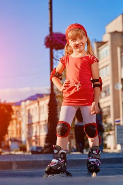 Sevimli küçük kız açık havada güzel yaz gününde paten için kırmızı t-shirt öğrenme