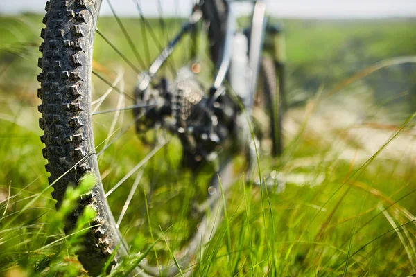 Close-up de detalhes da bicicleta de montanha na grama verde . — Fotografia de Stock