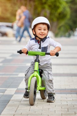 Mutlu çocuk beyaz kask içinde ilk Bisiklete binmek