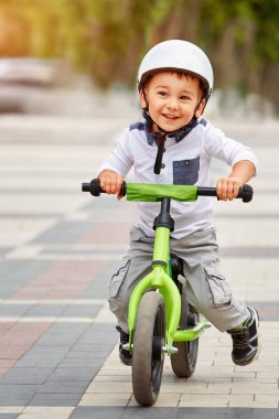 Mutlu çocuk beyaz kask içinde ilk Bisiklete binmek