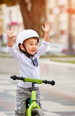 Mutlu çocuk beyaz kask içinde ilk Bisiklete binmek