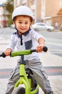 Mutlu çocuk beyaz kask içinde ilk Bisiklete binmek