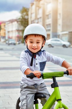 Mutlu çocuk beyaz kask içinde ilk Bisiklete binmek