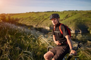 Dağ bisikleti adventur. Bisikletçi bir dinlenme riverside üzerinde vardır.