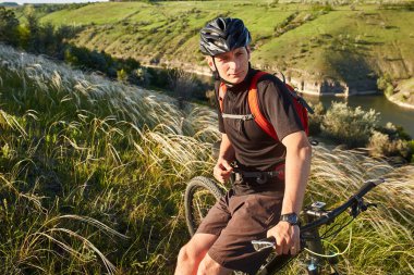 Dağ bisikleti adventur. Bisikletçi bir dinlenme riverside üzerinde vardır..