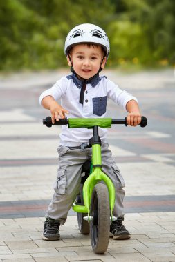 Küçük çocuk çocuk kask içinde Şehir Parkı içinde Bisiklete binmek. Çocuk açık.