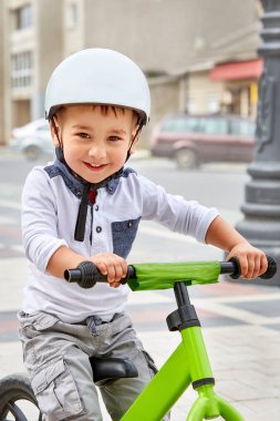 Küçük çocuk çocuk kask içinde Şehir Parkı içinde Bisiklete binmek. Çocuk açık.
