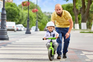 İlk ders binicilik bisiklet. Baba oğlu Bisiklete binmeyi öğretmek.
