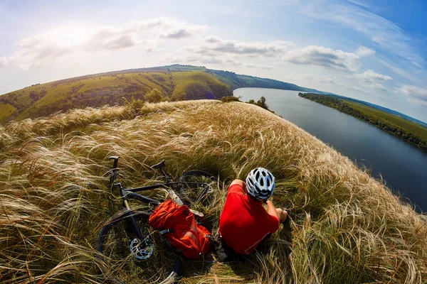 Avventuriero di mountain bike. Il ciclista ha un riposo su riva del fiume . — Foto Stock