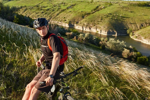 Aventura en bicicleta de montaña. El ciclista descansa a orillas del río . — Foto de Stock