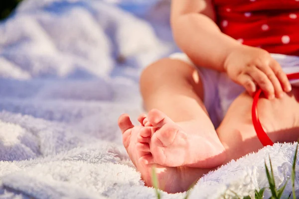 Primer plano de las pequeñas piernas del bebé sobre una hierba verde — Foto de Stock