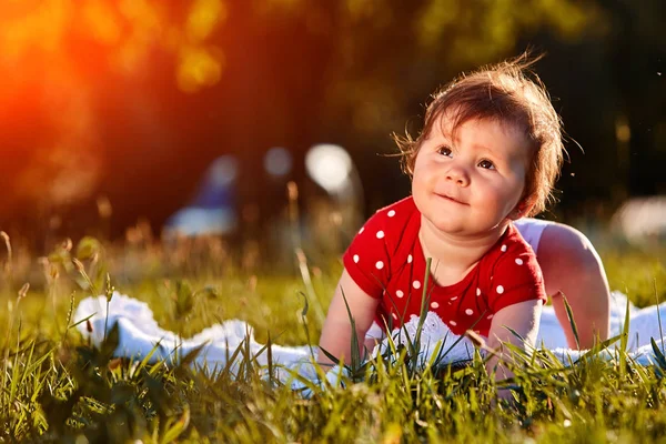 Primer plano retrato de verano de la hermosa niña en el césped en el parque . — Foto de Stock