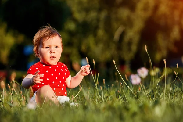 Primer plano retrato de verano de la hermosa niña en el césped en el parque . — Foto de Stock