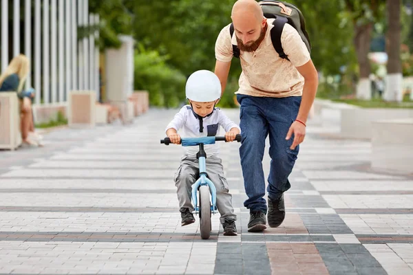 First lessons bicycle riding. Father teach his son to ride a bike.
