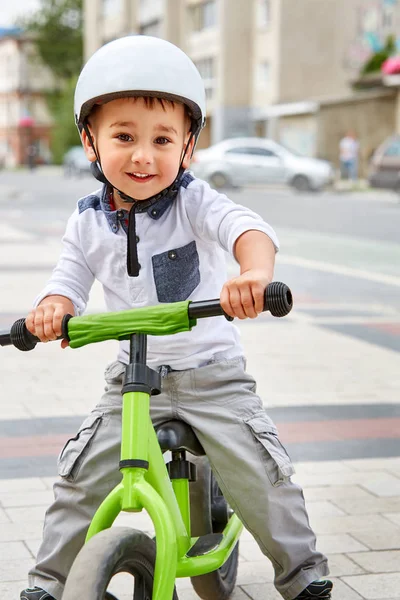 ヘルメットで小さな男の子子供公園で自転車に乗る。元気な子屋外. — ストック写真