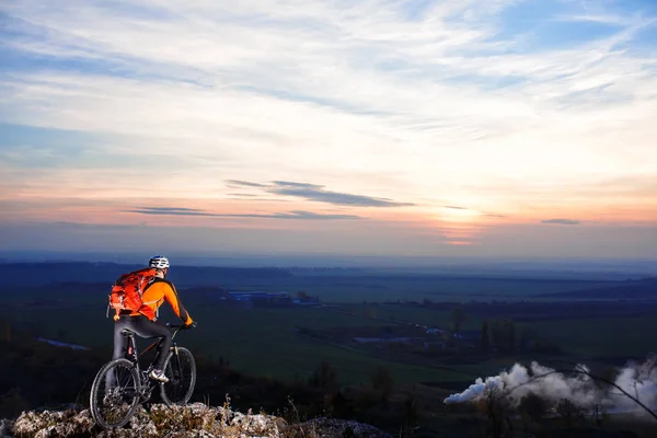 Cyklista s batohem na vrcholu kopce — Stock fotografie