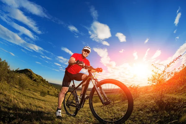Niski kąt widzenia rowerzysta stoi z rowerów górskich na szlaku na zachód słońca — Zdjęcie stockowe