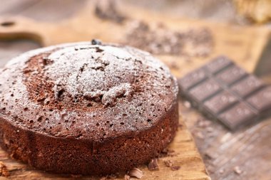 Tahta arka planda beyaz tabakta nefis çikolatalı pasta.