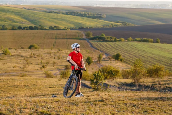 Dağ bisikleti motorcu turizm seyahat. Sonbahar manzara. Kırmızı forma ve beyaz kask bisikletle sporcu