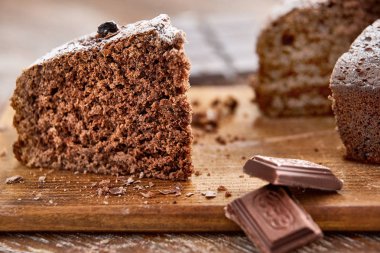 Tahta arka planda beyaz tabakta nefis çikolatalı pasta.