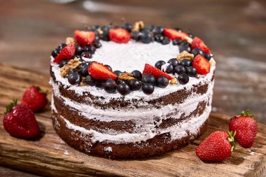 ahşap masa üzerine çırpılmış krema ve çilek meyve ile pastadan pay