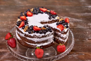 ahşap masa üzerine çırpılmış krema ve çilek meyve ile pastadan pay