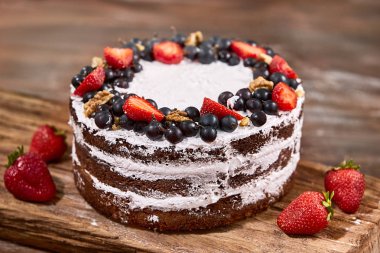 ahşap masa üzerine çırpılmış krema ve çilek meyve ile pastadan pay