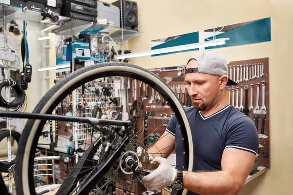 Mecánico de bicicletas en un taller en el proceso de reparación — Foto de Stock