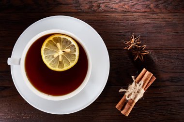 Beyaz porselen fincan çay tarçın, limon, nane yaprakları ve çay süzgeci