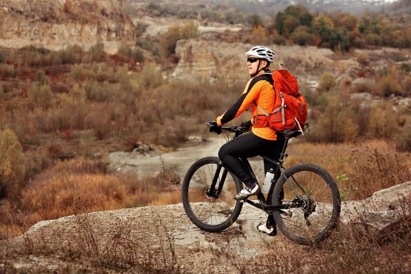 Back view of a man with a bicycle and red backpack against the blue sky. cyclist rides a bicycle. — Stock Photo, Image