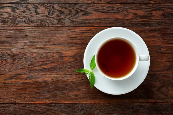 Tazza con tè verde e teiera su sfondo di legno — Foto Stock