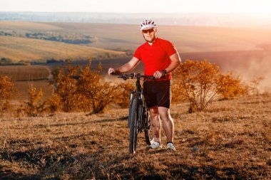Güzel sonbahar üzerinde Bisiklete binmek sırt çantası ile seyahat