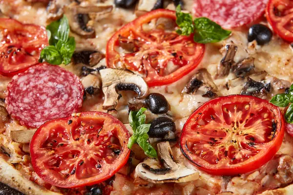 Primer plano de pizza con salami, tomates y aceitunas — Foto de Stock