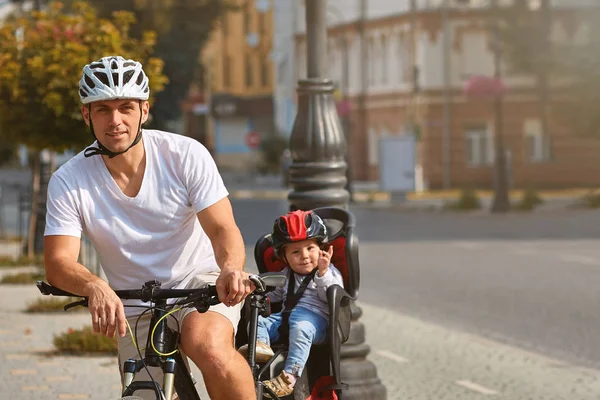 Active family riding bikes in the park summer day