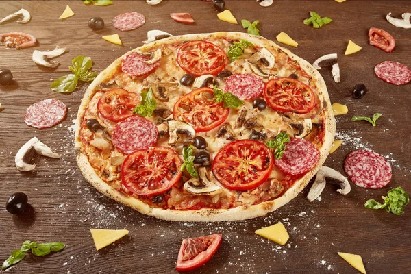 Pizza domates, mozzarella peyniri, Siyah Zeytin ve fesleğen. Lezzetli İtalyan pizza ahşap pizza yönetim kurulu.