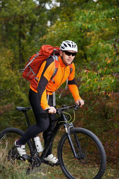 Mountain biking down the trail. Tourist with backpack travel on bike.