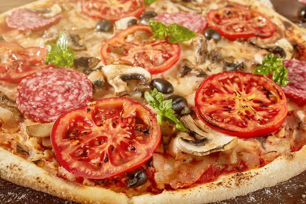 Pizza fresca con tomates, queso y champiñones sobre mesa de madera — Foto de Stock
