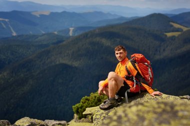 Genç erkek uzun yürüyüşe çıkan kimse sırt çantası rahatlatıcı sakin yaz gün batımı sırasında bir dağın tepesinde ile