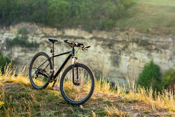 Bicicleta de montaña está solo al aire libre contra el otoño puesta de sol paisaje — Foto de Stock