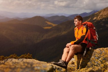bir kayanın üstünde seyahat etmek sırt çantası ile adam