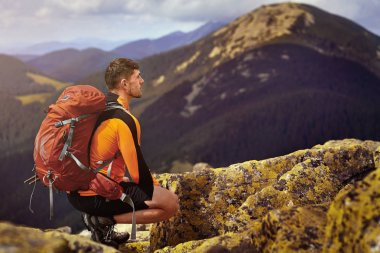 bir kayanın üstünde seyahat etmek sırt çantası ile adam