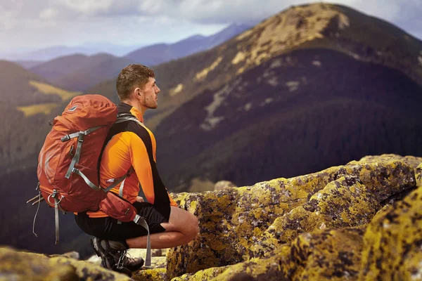 bir kayanın üstünde seyahat etmek sırt çantası ile adam