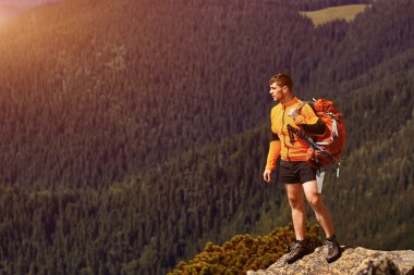 bir kayanın üstünde seyahat etmek sırt çantası ile adam