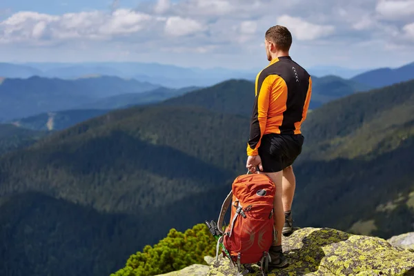 bir kayanın üstünde seyahat etmek sırt çantası ile adam