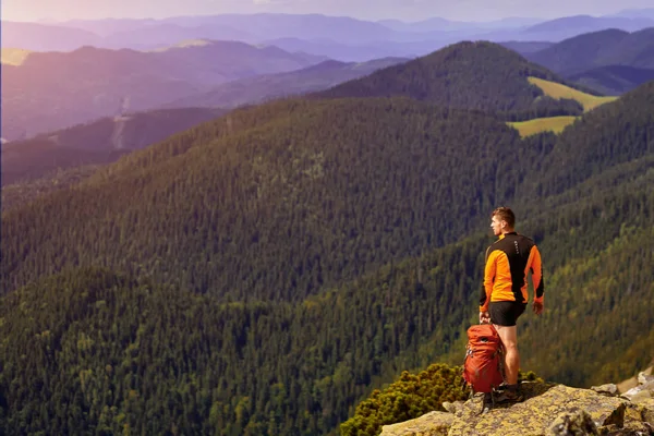 bir kayanın üstünde seyahat etmek sırt çantası ile adam