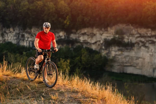 Joven hombre brillante en bicicleta de montaña en el paisaje de otoño — Foto de Stock